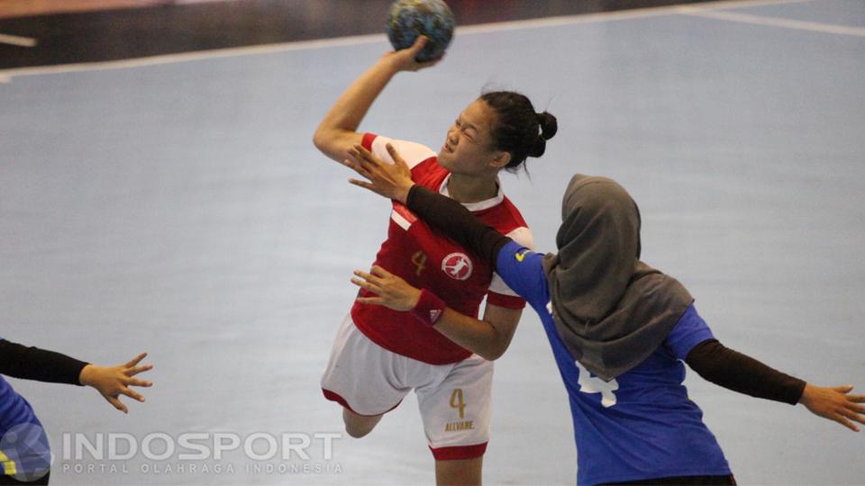 Pemain putri Indonesia (tengah) mendapat halangan saat ingin mencetak angka.